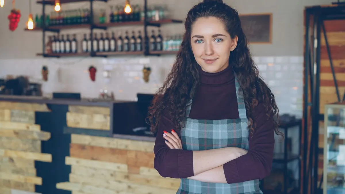Cafe owner standing inside a coffee shop